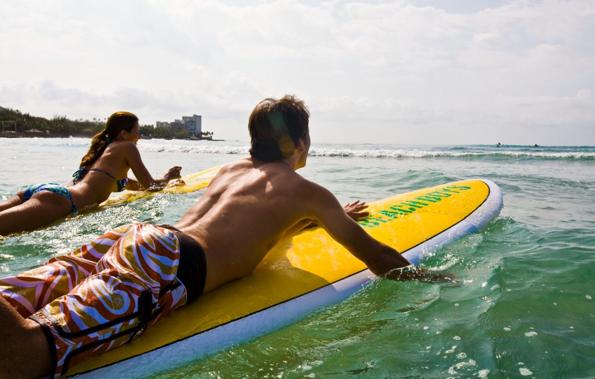 Couple surfing Waikiki Beach